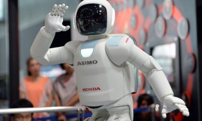 (FILES) This picture taken on July 3, 2013 shows Honda Motor's humanoid robot Asimo interacting with visitors at the National Museum of Emerging Science and Innovation in Tokyo on July 3, 2013. 
Launched in 2000, the humanoid machine resembling a shrunken spaceman has become arguably Japan's most famous robot, wheeled out to impress visiting politicians over the years. / AFP PHOTO / YOSHIKAZU TSUNO